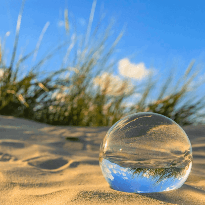 Reflektierende Glaskugel am Dünenstrand einer ostfriesischen Insel.